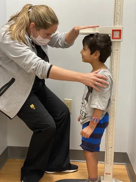 a boy getting his height measured by a doctor