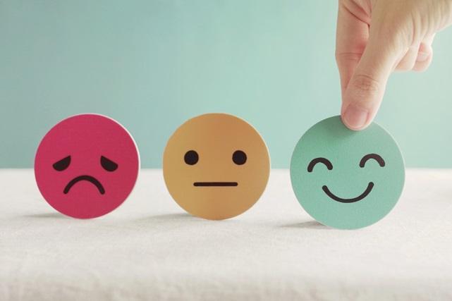 a sad, a neutral, and a smiling face tokens