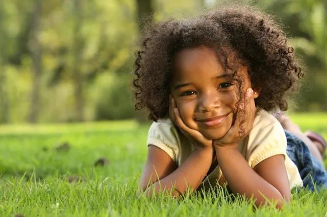 a girl lying in the grass smiling