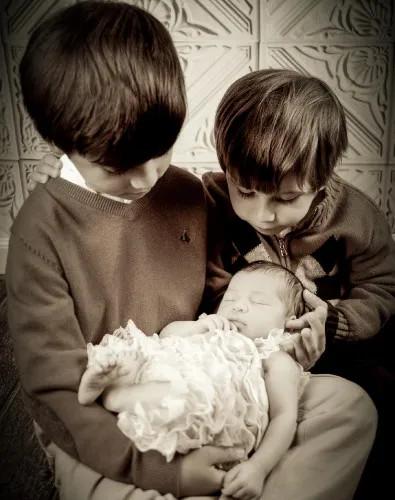 two boys holding a baby