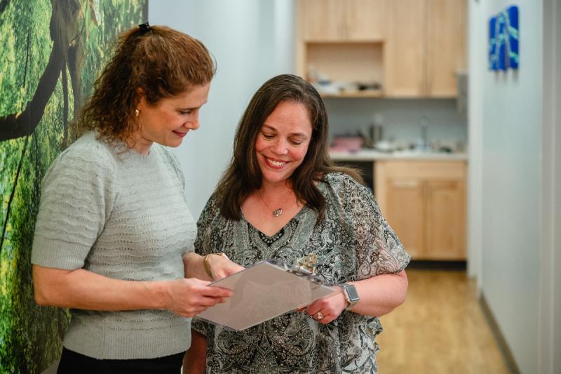 two medical providers talking with a clipboard