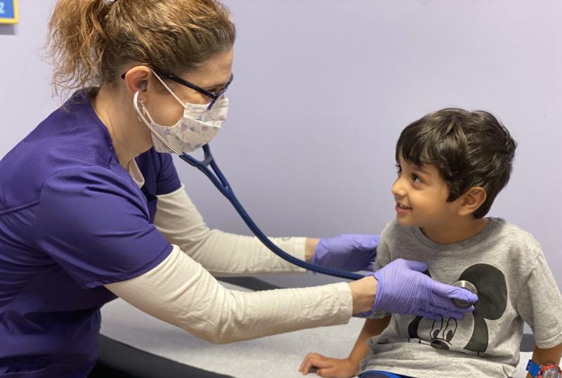 Clinician checks young boy's heart rate